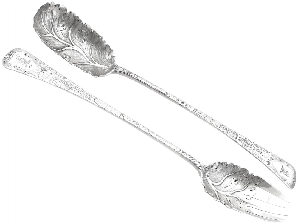 Pair of antique George III sterling silver salad servers with leaf-shaped bowls and engraved stems.