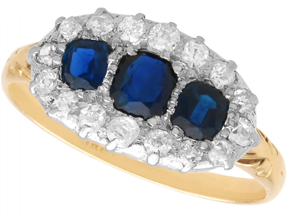 An 18ct yellow gold Victorian trilogy ring featuring three blue sapphires framed by a border of small diamonds.