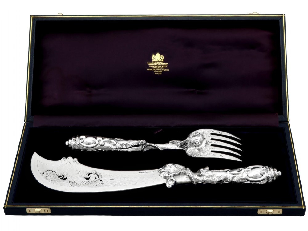 An engraved Victorian sterling silver fish serving knife and fork set presented inside a fitted black box.