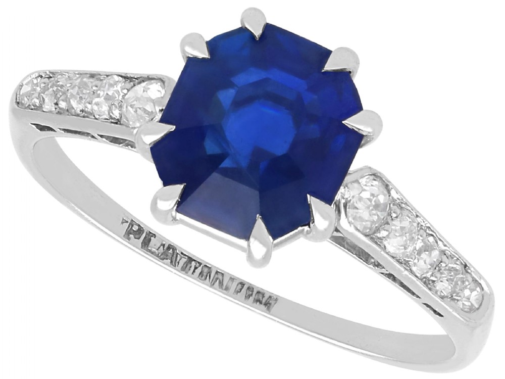 An Art Deco platinum solitaire ring set with an octagonal blue Burmese sapphire flanked by diamond-set shoulders.
