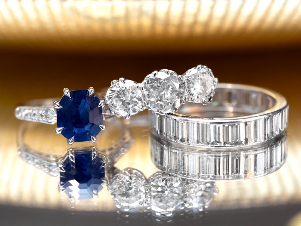 An Art Deco platinum solitaire ring set with an octagonal blue Burmese sapphire flanked by diamond-set shoulders. View V