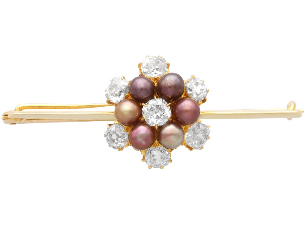 An antique 15ct yellow gold bar brooch featuring a central floral cluster set with dark pearls and old-cut diamonds.