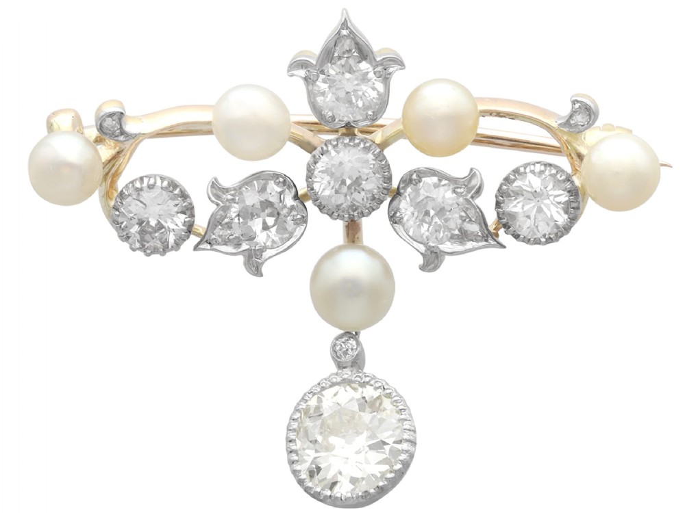 An Edwardian 9ct yellow gold brooch featuring old cut diamonds, pearls, and a central drop pendant.