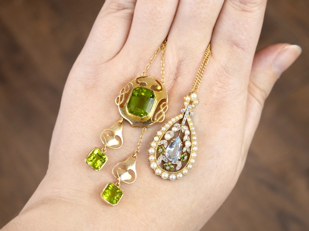 An Arts and Crafts 15ct yellow gold pendant necklace featuring a central emerald-cut peridot in a pierced openwork frame with two matching articulated peridot drops below. View III