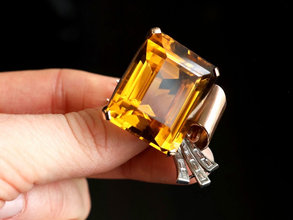 A large emerald-cut amber citrine stone set in a 14ct yellow gold brooch mounting accented with baguette diamonds. View III