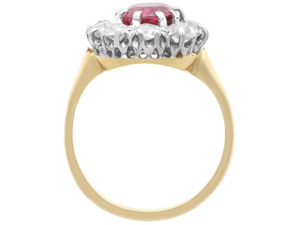 An antique 18ct yellow gold ring featuring a central oval red ruby set within a cluster halo of round white diamonds. View VIII