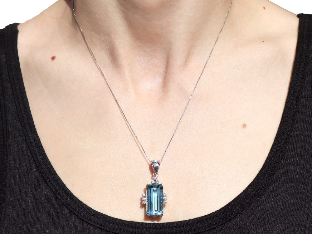 A vintage 18ct white gold pendant featuring a large emerald-cut light blue aquamarine framed by accent diamonds, suspended from an engraved bail. View XII