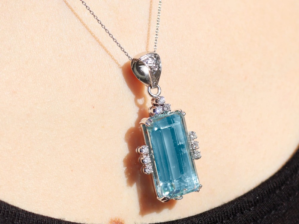 A vintage 18ct white gold pendant featuring a large emerald-cut light blue aquamarine framed by accent diamonds, suspended from an engraved bail. View XIII