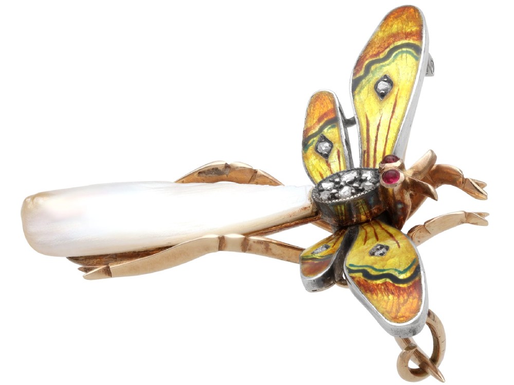 An antique late Victorian dragonfly brooch crafted in yellow gold with yellow enamel wings, garnet eyes, rose-cut diamond accents, and a elongated natural pearl abdomen. View VII