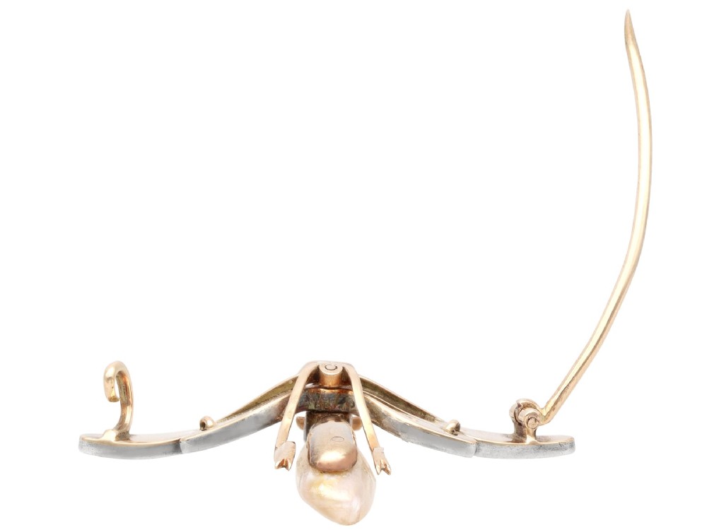 An antique late Victorian dragonfly brooch crafted in yellow gold with yellow enamel wings, garnet eyes, rose-cut diamond accents, and a elongated natural pearl abdomen. View IX