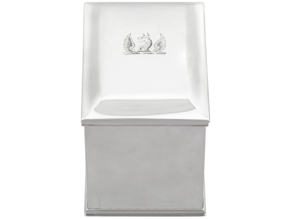 A rectangular George III sterling silver tea caddy featuring a fitted cover engraved with a heraldic crest and stepped moulded borders along the base and top. View IV