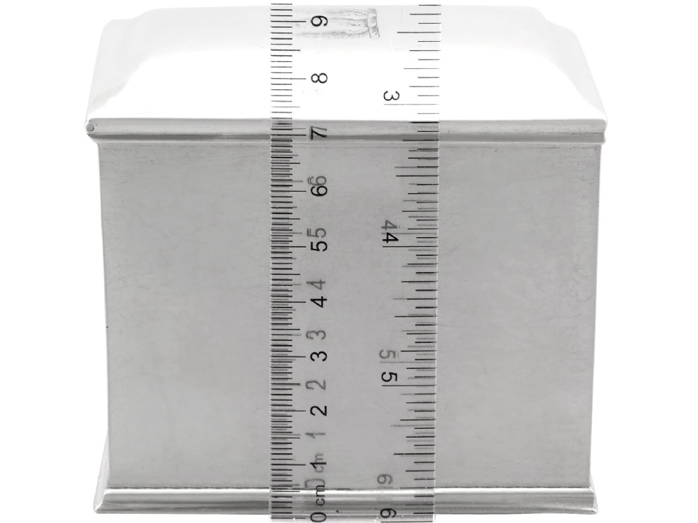 A rectangular George III sterling silver tea caddy featuring a fitted cover engraved with a heraldic crest and stepped moulded borders along the base and top. View X