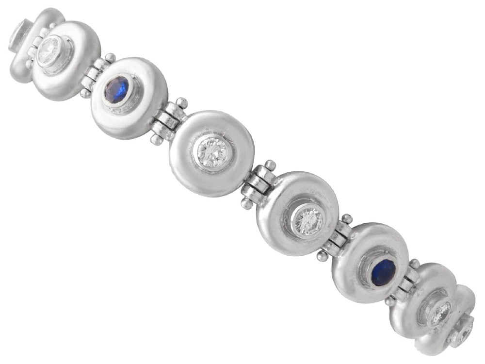 A vintage 18ct white gold articulated link bracelet set with alternating bezel-mounted round diamonds and blue sapphires.