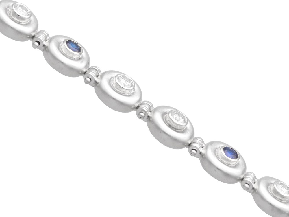 A vintage 18ct white gold articulated link bracelet set with alternating bezel-mounted round diamonds and blue sapphires. View VII