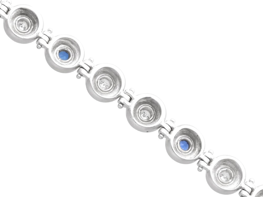 A vintage 18ct white gold articulated link bracelet set with alternating bezel-mounted round diamonds and blue sapphires. View VIII