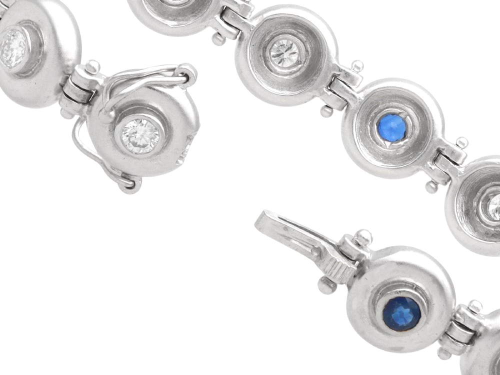 A vintage 18ct white gold articulated link bracelet set with alternating bezel-mounted round diamonds and blue sapphires. View X