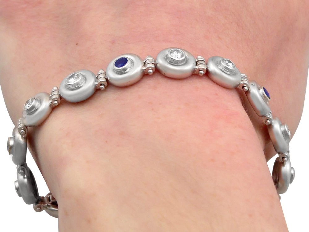 A vintage 18ct white gold articulated link bracelet set with alternating bezel-mounted round diamonds and blue sapphires. View XV