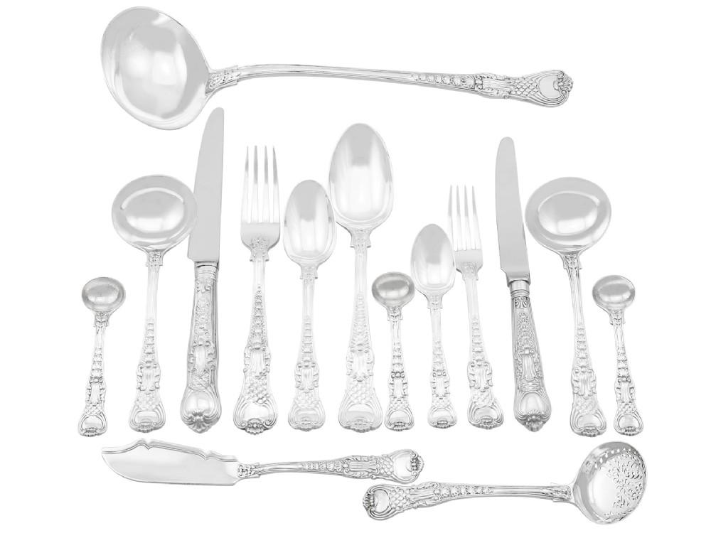 A collection of ornate sterling silver cutlery pieces featuring intricately embossed handles and polished bowls, including ladles, forks, knives, and spoons.