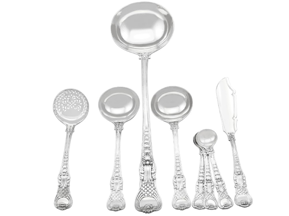 A collection of ornate sterling silver cutlery pieces featuring intricately embossed handles and polished bowls, including ladles, forks, knives, and spoons. View II