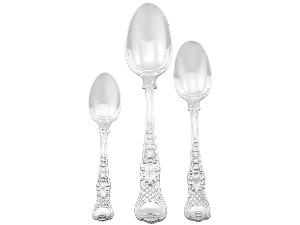 A collection of ornate sterling silver cutlery pieces featuring intricately embossed handles and polished bowls, including ladles, forks, knives, and spoons. View VI