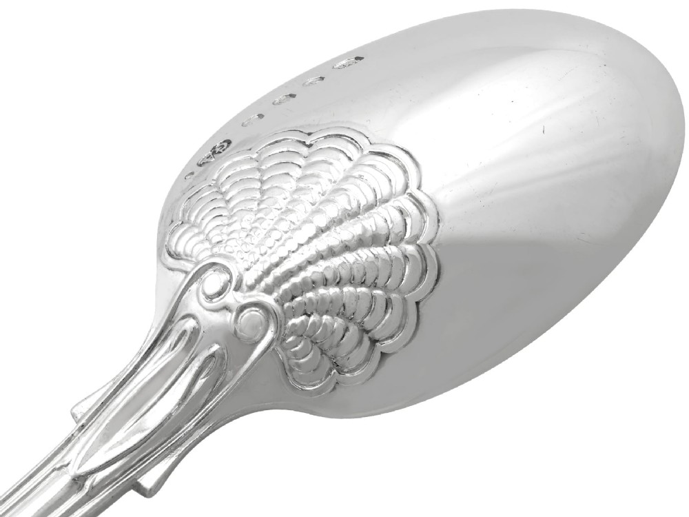 A collection of ornate sterling silver cutlery pieces featuring intricately embossed handles and polished bowls, including ladles, forks, knives, and spoons. View XI