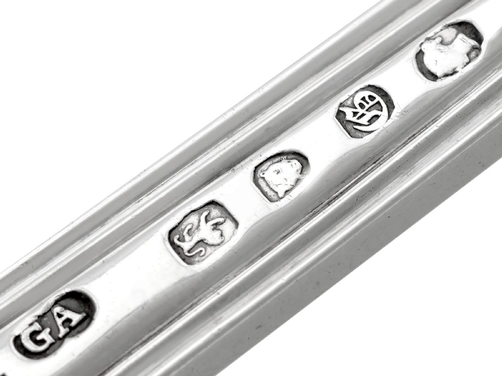 A collection of ornate sterling silver cutlery pieces featuring intricately embossed handles and polished bowls, including ladles, forks, knives, and spoons. View XII