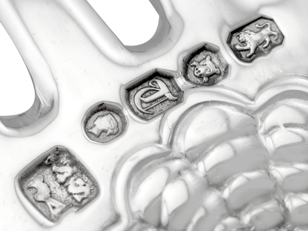 A collection of ornate sterling silver cutlery pieces featuring intricately embossed handles and polished bowls, including ladles, forks, knives, and spoons. View XIII