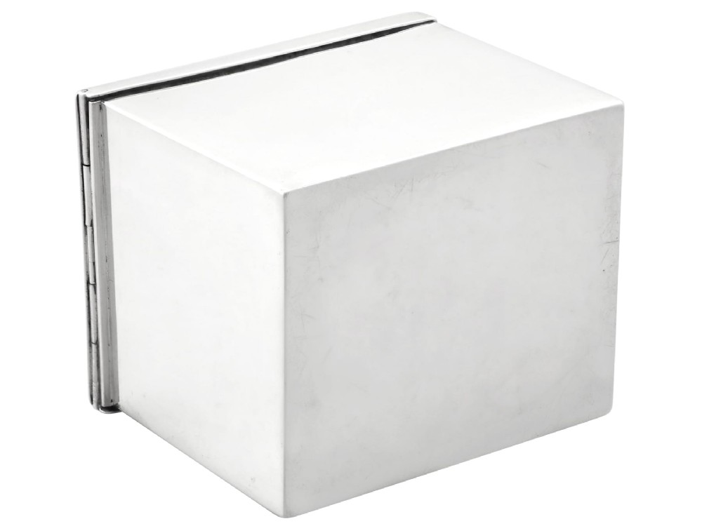 A rectangular Victorian sterling silver tea caddy featuring an engraved crest, top folding handle, and visible side hallmarks. View XI