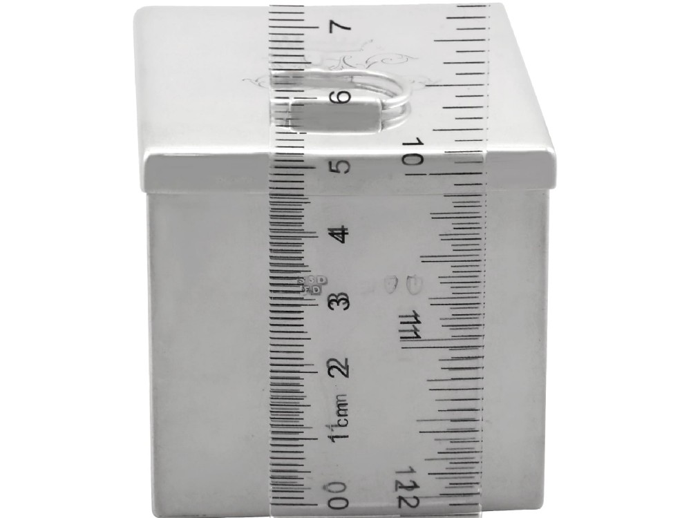 A rectangular Victorian sterling silver tea caddy featuring an engraved crest, top folding handle, and visible side hallmarks. View XII