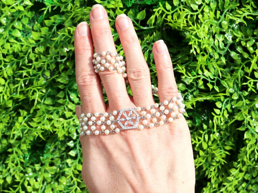 A multi-strand white pearl choker necklace joined at the front by an 18ct white gold hexagonal plaque set with small diamonds. View II