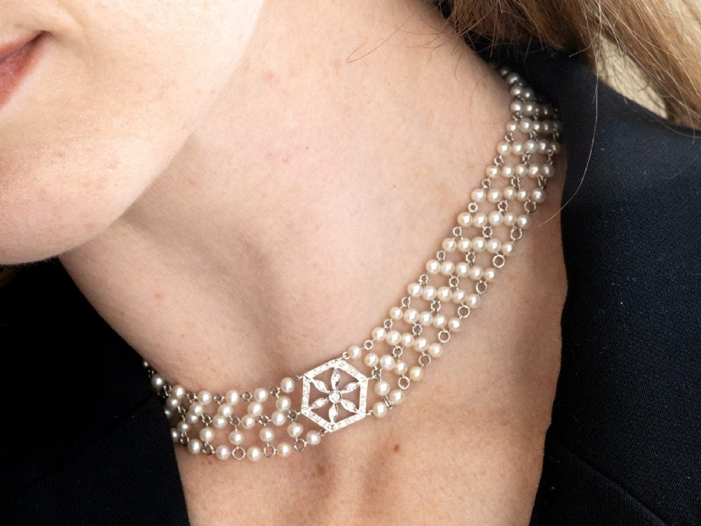 A multi-strand white pearl choker necklace joined at the front by an 18ct white gold hexagonal plaque set with small diamonds. View VII