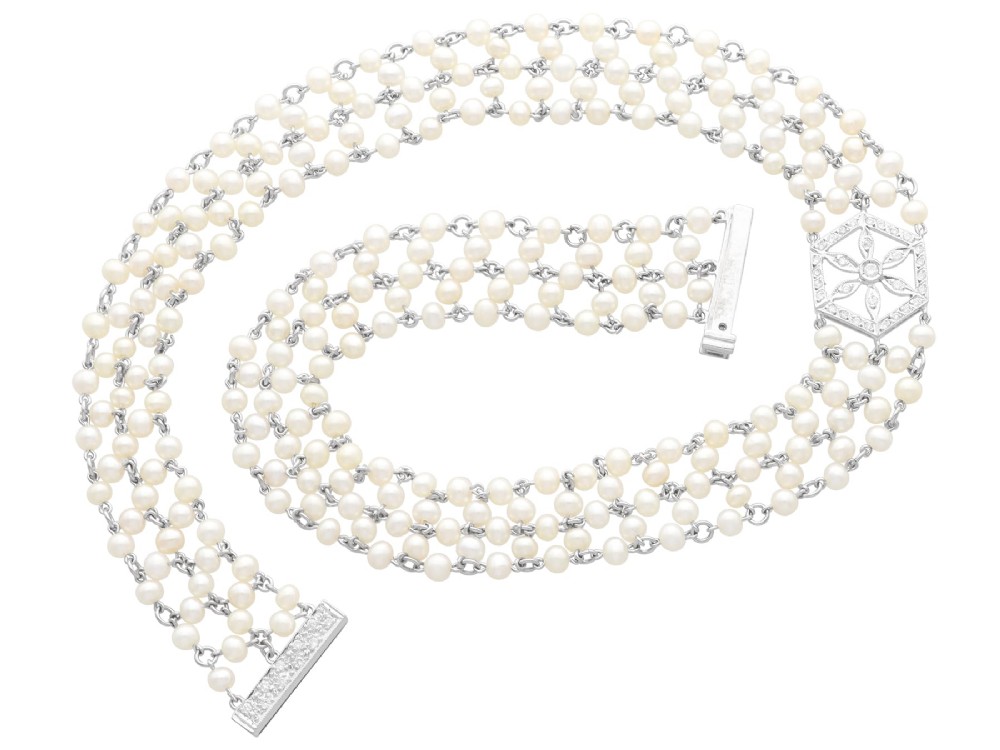 A multi-strand white pearl choker necklace joined at the front by an 18ct white gold hexagonal plaque set with small diamonds. View VIII