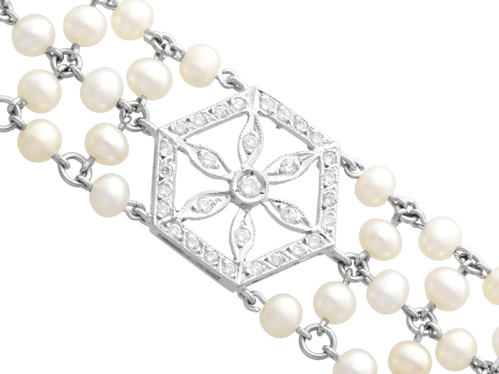 A multi-strand white pearl choker necklace joined at the front by an 18ct white gold hexagonal plaque set with small diamonds. View IX