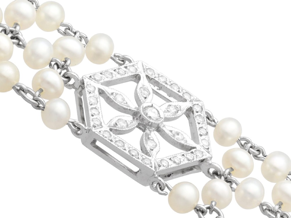 A multi-strand white pearl choker necklace joined at the front by an 18ct white gold hexagonal plaque set with small diamonds. View X
