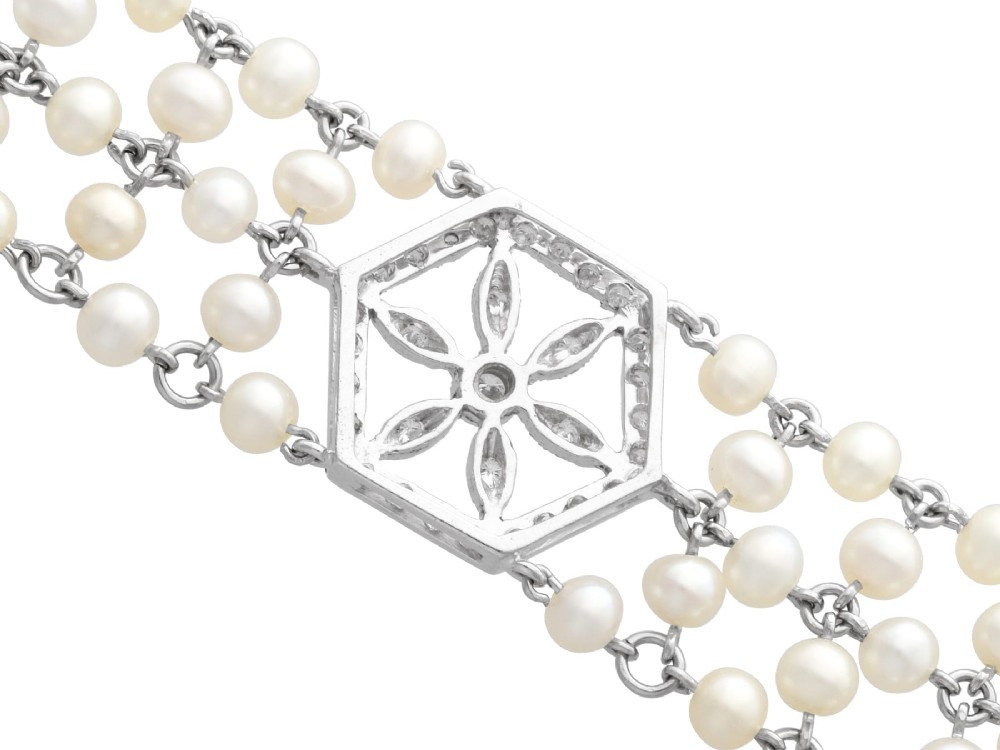 A multi-strand white pearl choker necklace joined at the front by an 18ct white gold hexagonal plaque set with small diamonds. View XII