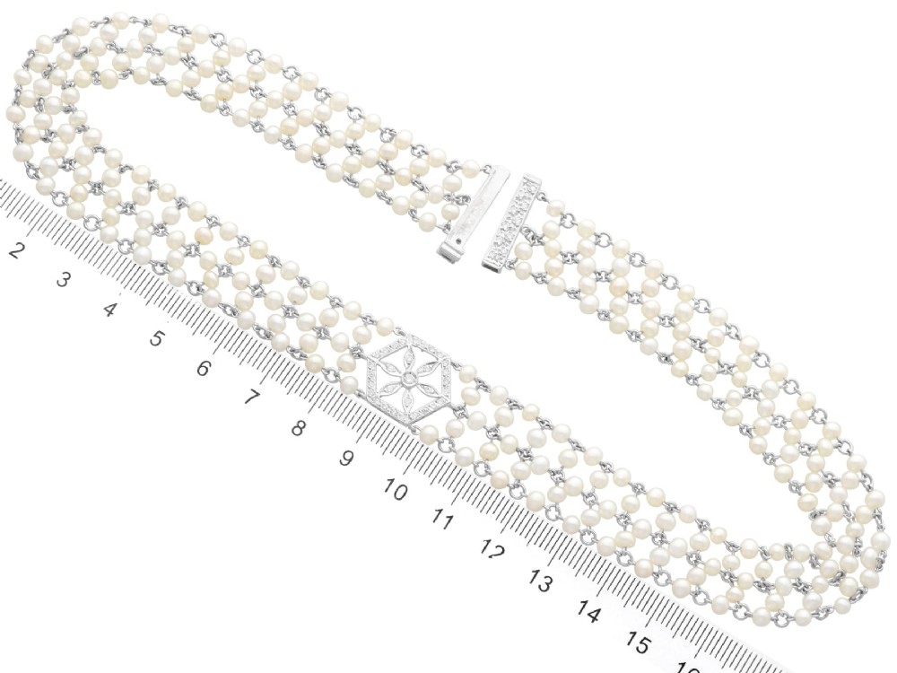 A multi-strand white pearl choker necklace joined at the front by an 18ct white gold hexagonal plaque set with small diamonds. View XIII