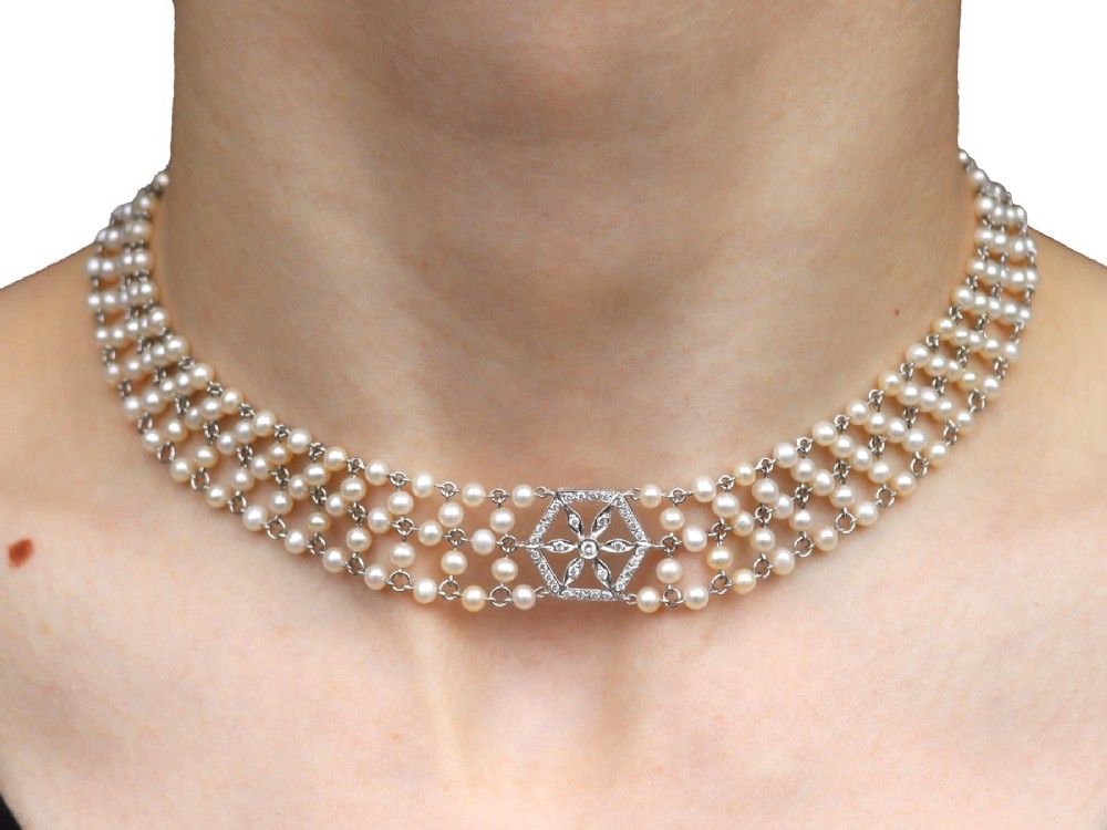 A multi-strand white pearl choker necklace joined at the front by an 18ct white gold hexagonal plaque set with small diamonds. View XV