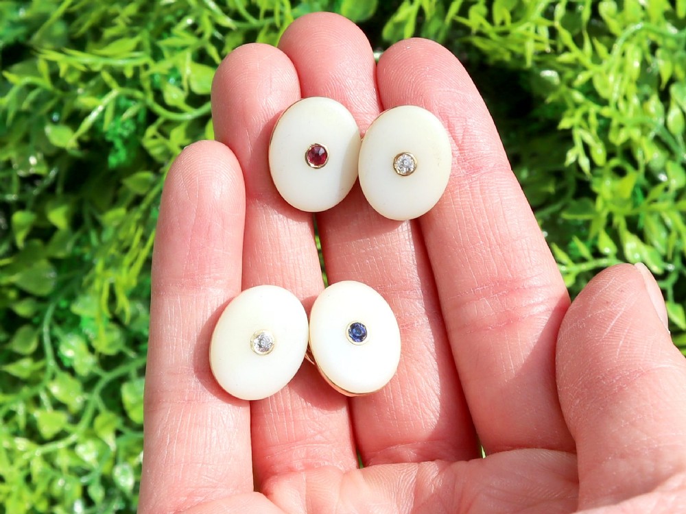 Four oval 15ct yellow gold cufflinks featuring smooth white agate faces with central bezel-set diamond, sapphire, and ruby gemstones. View II