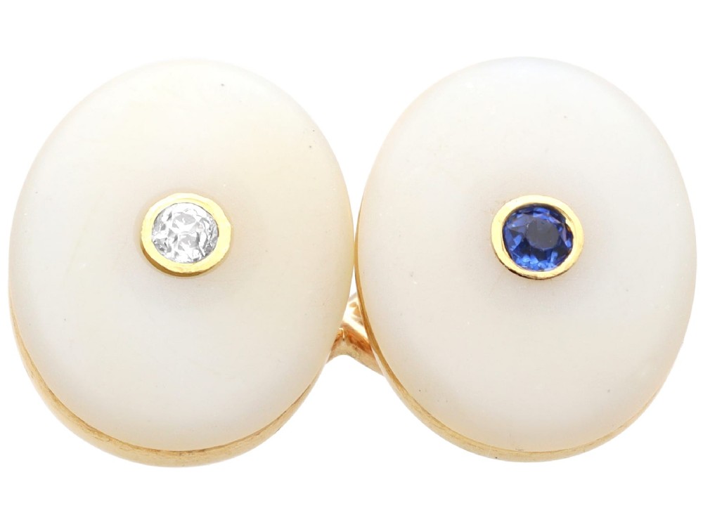 Four oval 15ct yellow gold cufflinks featuring smooth white agate faces with central bezel-set diamond, sapphire, and ruby gemstones. View VI