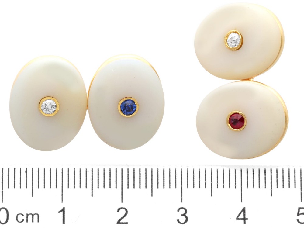 Four oval 15ct yellow gold cufflinks featuring smooth white agate faces with central bezel-set diamond, sapphire, and ruby gemstones. View XI
