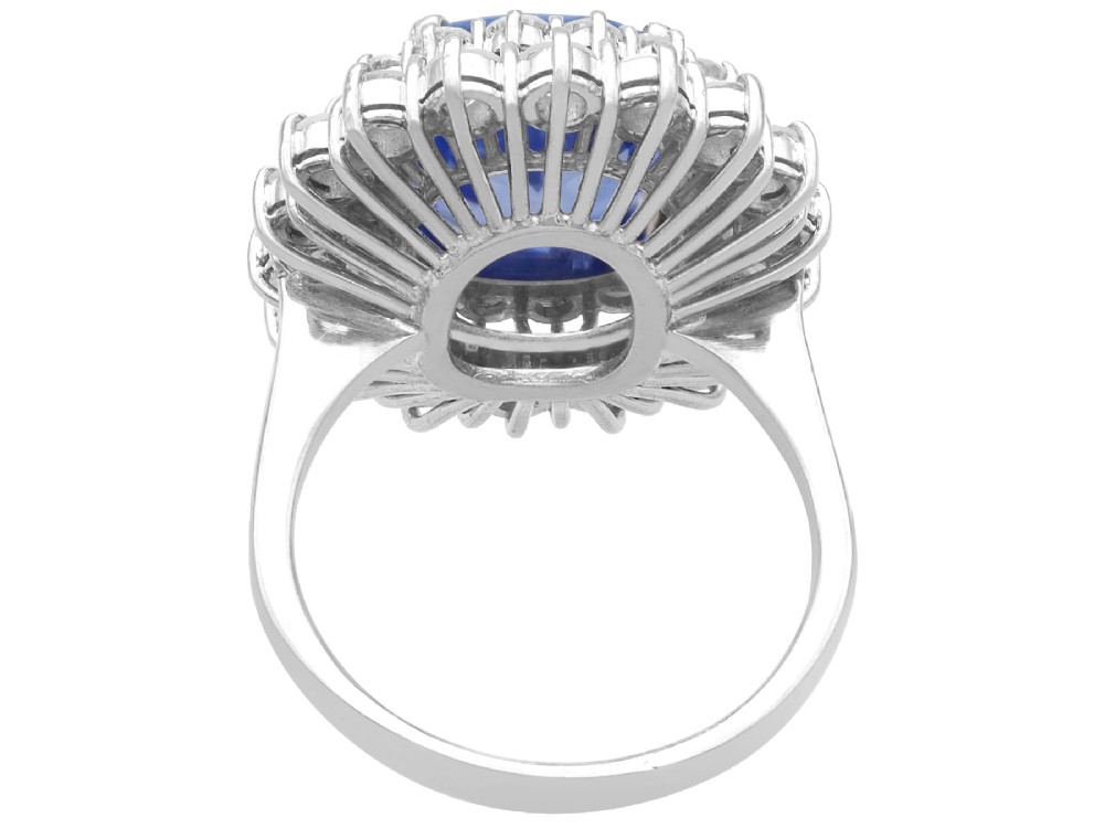 A vintage 14ct white gold cluster ring featuring a centrally mounted cushion-cut blue Ceylon sapphire surrounded by a double halo of round brilliant diamonds. View VII