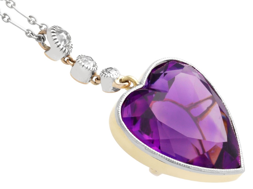 An antique heart-cut purple amethyst pendant framed with a millegrain edge and suspended beneath three round diamond accents set in gold. View IX