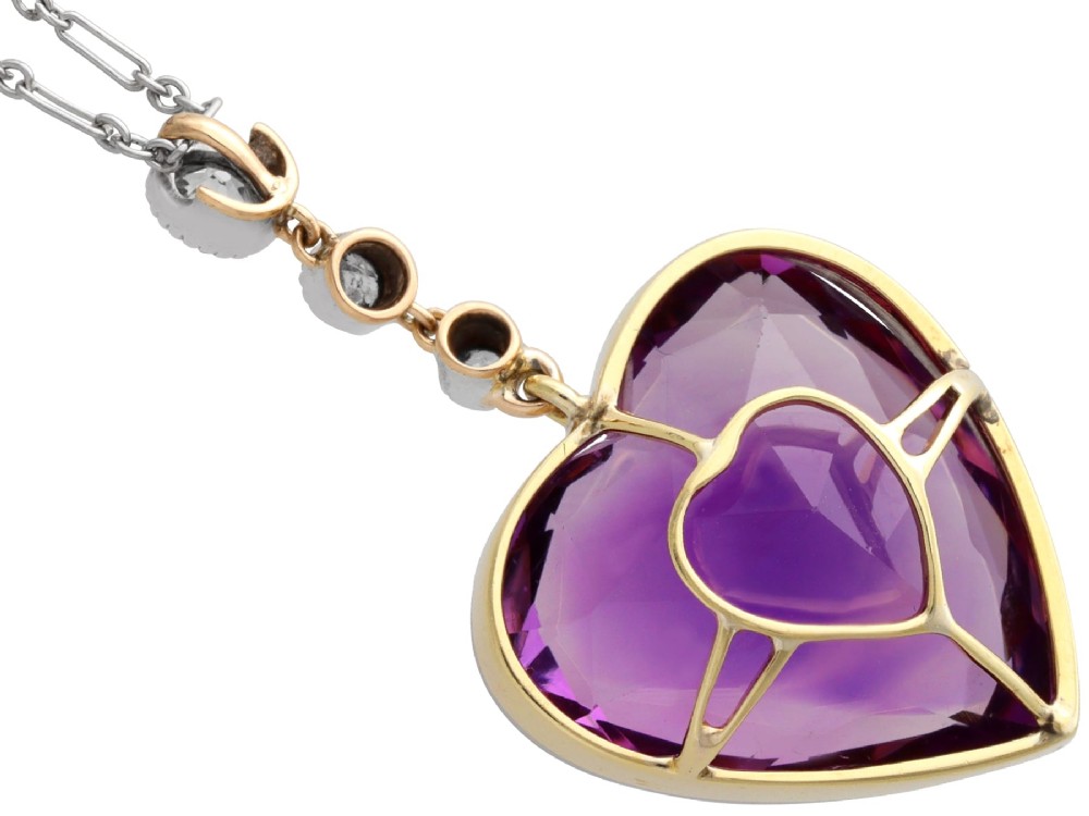 An antique heart-cut purple amethyst pendant framed with a millegrain edge and suspended beneath three round diamond accents set in gold. View X