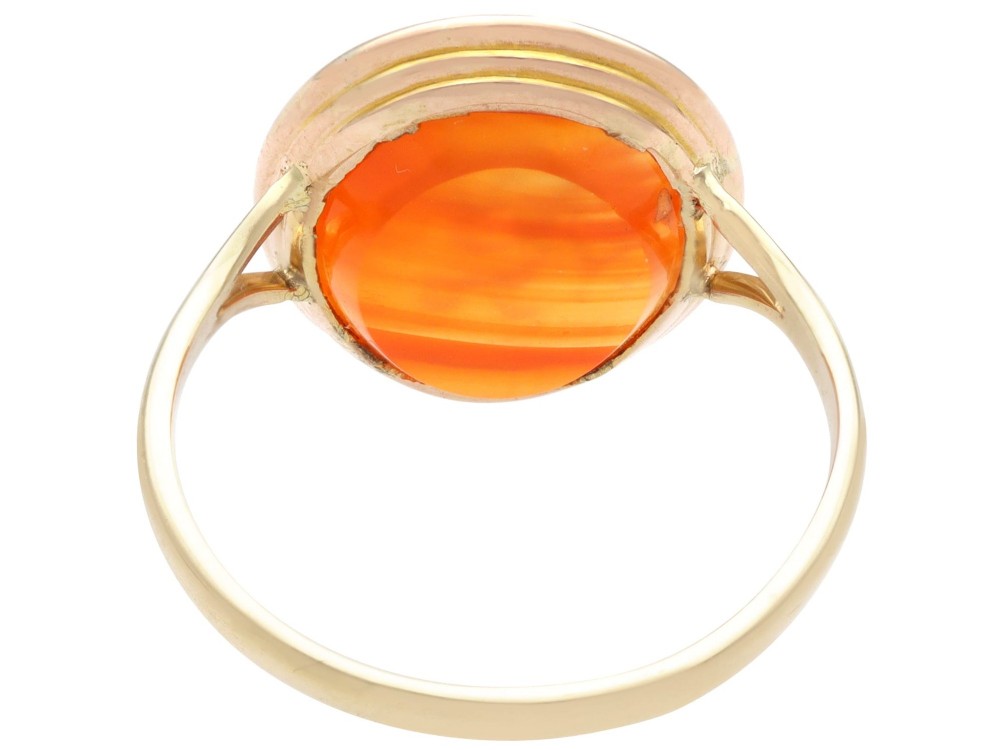 An antique 9ct yellow gold ring featuring an oval carved orange agate intaglio depicting a figure with split shoulders. View VIII