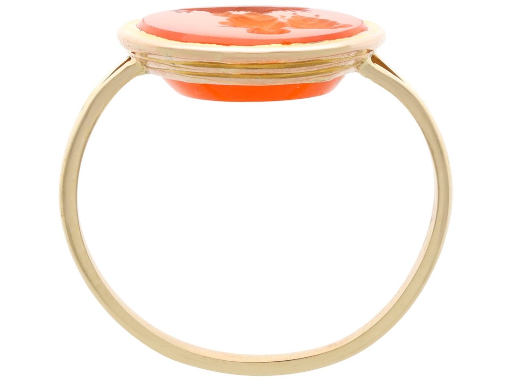 An antique 9ct yellow gold ring featuring an oval carved orange agate intaglio depicting a figure with split shoulders. View IX