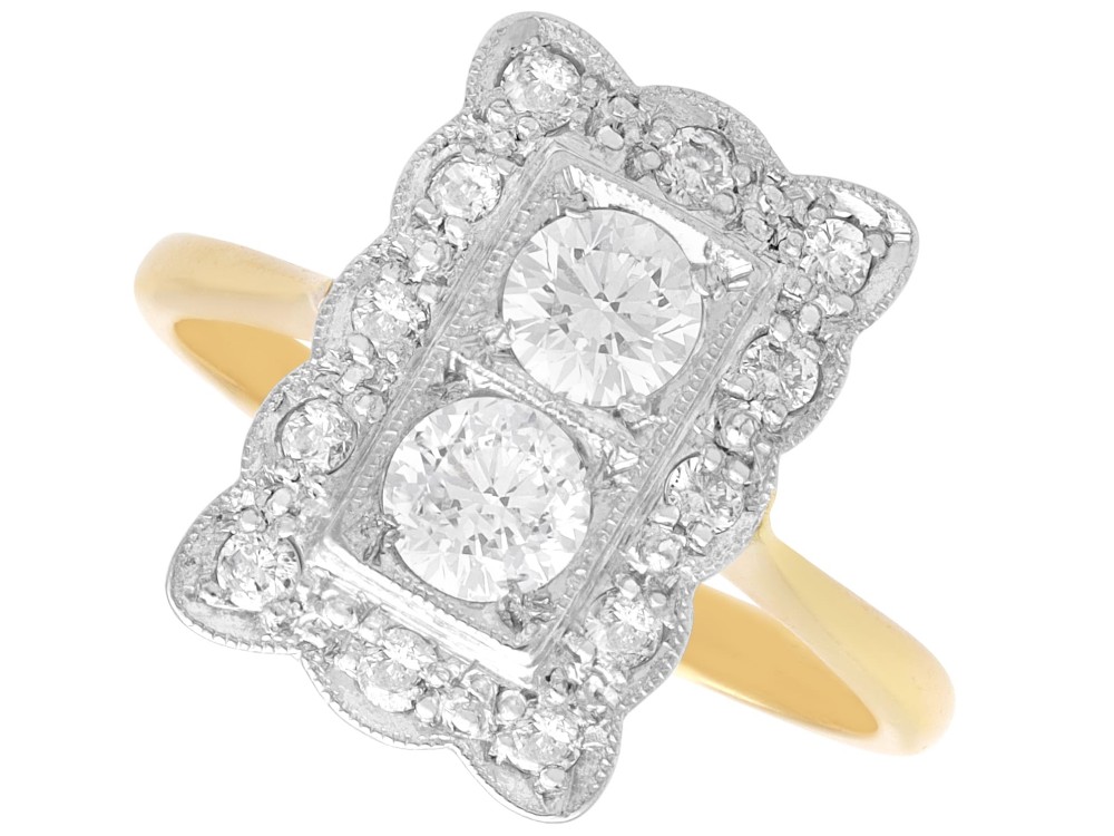 An Art Deco 18ct yellow gold dress ring with two central round diamonds within a rectangular millegrain halo setting.