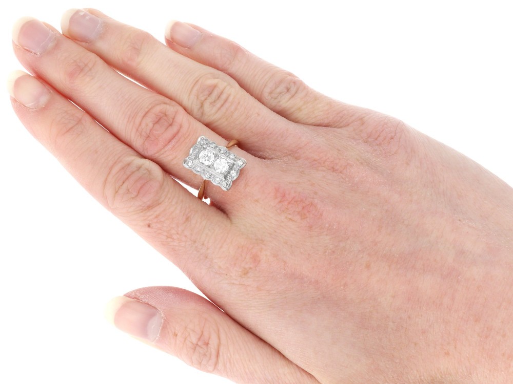 An Art Deco 18ct yellow gold dress ring with two central round diamonds within a rectangular millegrain halo setting. View X