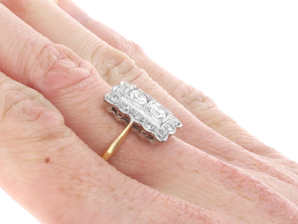 An Art Deco 18ct yellow gold dress ring with two central round diamonds within a rectangular millegrain halo setting. View XI