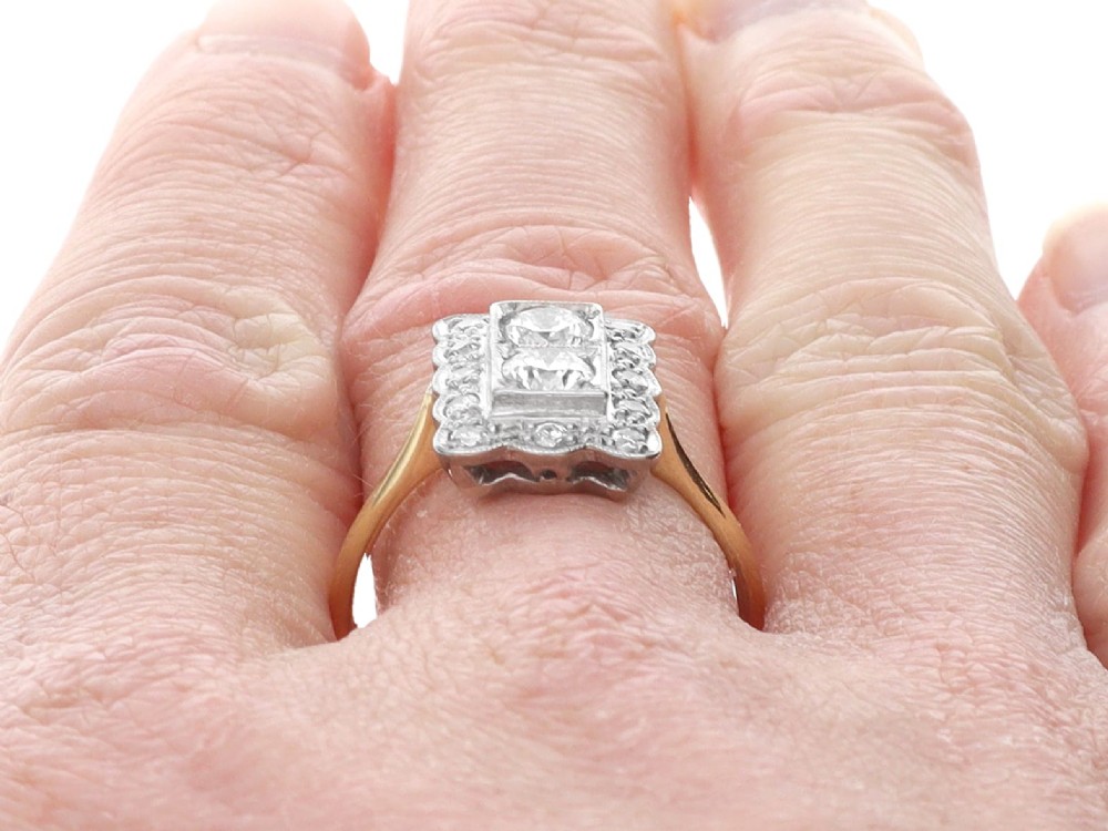An Art Deco 18ct yellow gold dress ring with two central round diamonds within a rectangular millegrain halo setting. View XII