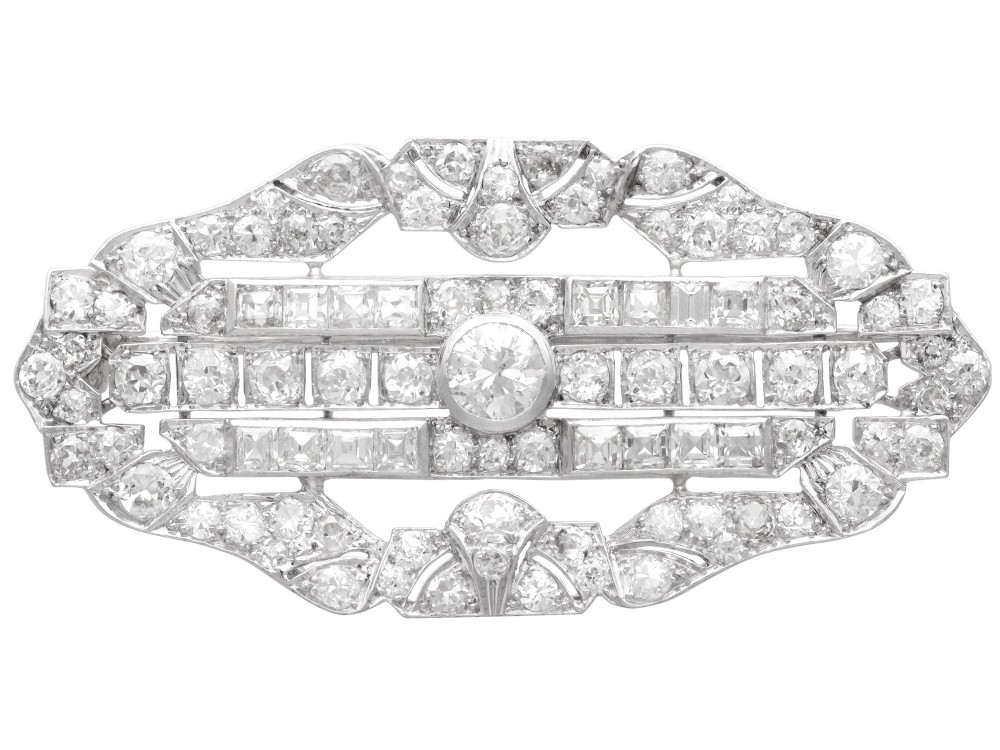 An Art Deco platinum brooch styled in an elongated geometric openwork plaque pattern, set throughout with brilliant and square-cut diamonds.